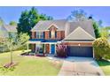 Attractive two-story home featuring a brick facade, well-kept lawn, and attached two-car garage at 3049 Battlement, Loganville, GA 30052