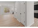 Hallway featuring a modern white interior, two doors, and light wood flooring at 5086 Cumberland Ct, Villa Rica, GA 30180