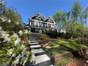 Beautiful two story lake house with a gray staircase and lush landscaping at 6255 Lakeview Dr, Buford, GA 30518