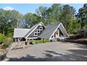 A-frame house with a gravel driveway and lush landscaping at 6255 Lakeview Dr, Buford, GA 30518