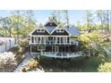 Charming two-story home features a beautiful deck, steps leading to the house, and lush landscaping at 6255 Lakeview Dr, Buford, GA 30518
