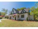 Lovely home with cream and green paint, complemented by a well-kept lawn and classic American flag at 181 W Hightower Trl, Social Circle, GA 30025