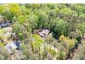 An aerial view of a house surrounded by lush greenery and mature trees in a wooded neighborhood at 3141 Burnt Hickory Nw Rd, Marietta, GA 30064