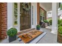 Inviting front porch with decorative wreath, stylish door mat, and comfortable seating area at 3870 Cabalzar St, Cumming, GA 30040