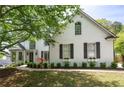 Beautiful white brick home with lush landscaping, arched windows, and a welcoming front entrance at 648 Gold Valley Pass, Canton, GA 30114