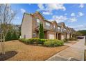 Angle view of townhomes with brick and beige siding, along with landscaping at 7779 Haynes Park Cir, Lithonia, GA 30038