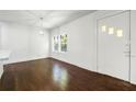 Bright living room with hardwood floors, light fixture and a white front door with decorative windows at 3460 Old Fairburn Rd, South Fulton, GA 30349