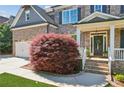 Attractive brick home featuring a well-manicured lawn and charming front porch with detailed trim at 6414 Blue Water Dr, Buford, GA 30518