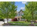 Charming brick home with manicured lawn, mature trees, and inviting front porch with covered entrance at 6414 Blue Water Dr, Buford, GA 30518