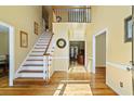 Bright foyer with hardwood floors, staircase, and a view to a living room through an arched entryway at 815 Kings Arms Way, Alpharetta, GA 30022