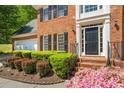 Up close front elevation showcasing the brick facade, detailed front door, and meticulously maintained landscaping at 815 Kings Arms Way, Alpharetta, GA 30022