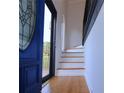 Welcoming foyer featuring a bright blue front door, wood floors and staircase leading to the second floor at 4270 Mountain Glen Trce, Snellville, GA 30039