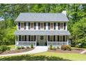 Inviting two-story home featuring a welcoming front porch and lush green lawn at 6005 Cherecobb Ln, Woodstock, GA 30188