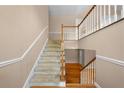 Well-lit staircase with carpeted steps and wooden railing, leading to the second floor at 4512 Terret Nw Trce, Acworth, GA 30101