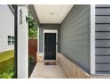 Inviting front porch with a black front door, brick accents, and gray siding at 458 Burgundy Se Ter, Atlanta, GA 30354