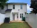 View of the white fenced-in backyard with grass and a door leading into the house at 5897 Strathmoor Manor Cir, Lithonia, GA 30058