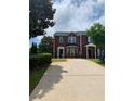 Exterior of red brick two-story house with green shutters and a driveway in front of the house at 5897 Strathmoor Manor Cir, Lithonia, GA 30058