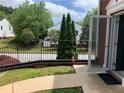 View of the front porch with an iron railing and some trees and shrubs in the background at 5897 Strathmoor Manor Cir, Lithonia, GA 30058