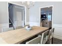 Open-concept dining room with elegant chandelier and easy access to the kitchen and stairs at 3419 Mulberry Cove Way, Auburn, GA 30011
