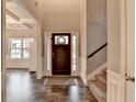 Open foyer with dark wood floors, a staircase, and a glimpse into the bright living spaces at 3419 Mulberry Cove Way, Auburn, GA 30011