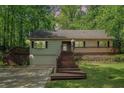 Charming home with a deck, featuring mature trees, a well-maintained front yard and an attached garage at 1373 Janice Sw Ct, Lilburn, GA 30047