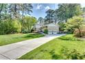 Spacious home featuring an extra long driveway, attached garage, and a lush green lawn at 1631 Manhasset Dr, Atlanta, GA 30338