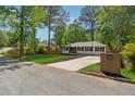 A beautifully landscaped home with green grass, dark mulch, a fence, and a newly paved driveway at 1737 Briarlake Cir, Decatur, GA 30033