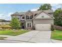 Beautiful two-story home with a brick facade, well-kept lawn, attached garage, and delightful landscaping at 3126 Cove View Ct, Dacula, GA 30019