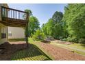 Lush backyard with mature trees, a wooden deck and a community playground for outdoor fun and relaxation at 3140 Ennfield Ln, Duluth, GA 30096