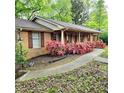 Charming brick home with a covered porch, blossoming azaleas, and a manicured lawn at 1901 Arnold Dr, Austell, GA 30106
