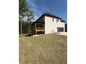 Spacious backyard showcasing a covered patio, attached garage, and lush green lawn at 409 Saint Surrey Way, Ellenwood, GA 30294