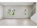 Open-concept living room with staircase and plenty of natural light at 1280 Firefly Field Trce, Lawrenceville, GA 30045