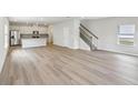 Open-concept living space showcases the modern flooring, staircase, and kitchen in neutral tones at 1290 Firefly Field Trce, Lawrenceville, GA 30045