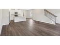 Open-concept living space with laminate floors leading to a modern kitchen at 1270 Firefly Field Trce, Lawrenceville, GA 30045