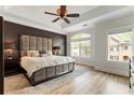 Elegant main bedroom features tray ceiling, hardwood floors, a plush bed and ample natural light from large windows at 5523 Glenridge Ne Park, Atlanta, GA 30342