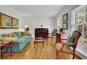 Bright living room with hardwood floors, piano, and large windows offering great natural light at 1569 Chateau Dr, Dunwoody, GA 30338