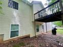 Back exterior of home with elevated deck, lower patio, and walkout basement door at 25 Derby Dr, Hiram, GA 30141