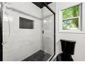 Updated bathroom with tiled walk-in shower, black fixtures, and a window view at 2302 Aurie Dr, Decatur, GA 30034