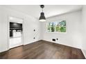 Dining area with dark floors, modern pendant lighting, a window with outside views and adjoining kitchen at 2302 Aurie Dr, Decatur, GA 30034