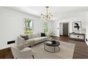 Bright living room featuring a modern chandelier, neutral walls, and wood floors at 2302 Aurie Dr, Decatur, GA 30034
