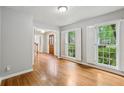 Bright living room featuring hardwood floors and large windows with white shutters at 1520 N Milford Creek Sw Ln, Marietta, GA 30008