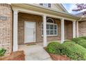 Inviting front porch featuring brick columns and manicured shrubbery at 1640 Arbor Green Nw Ct # 1102, Kennesaw, GA 30152