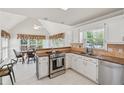 Bright kitchen featuring white cabinets, stainless steel appliances, granite countertops, and an adjacent dining area at 2849 Shiaway Trl, Snellville, GA 30039