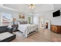 Relaxing main bedroom featuring a tray ceiling, wood floors, a ceiling fan, and neutral decor at 2849 Shiaway Trl, Snellville, GA 30039
