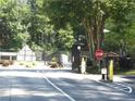 Gated community entrance showing a stop sign and security features in a lush, wooded setting at 4018 Woodridge Way, Tucker, GA 30084