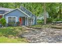 Charming blue home features a bright red front door, large window, and well-maintained lawn at 5126 Farm Place Ne Dr, Woodstock, GA 30188