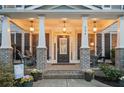 Inviting front porch with brick columns, pendant lights, and comfortable seating at 524 Tackett Farms Rd, Smyrna, GA 30082