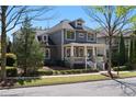 Two-story home with a large front porch and well-maintained landscaping on a sunny day at 9988 Devonshire St, Douglasville, GA 30135