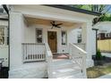 Inviting front porch featuring a stained wood ceiling, ceiling fan and updated white railing at 1555 Olympian Sw Way, Atlanta, GA 30310