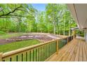 Spacious backyard featuring a wood deck and manicured lawn surrounded by lush trees and colorful landscaping at 2633 Jonesboro Rd, Fairburn, GA 30213